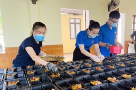 Thanh niên tình nguyện nấu cơm cho các y bác sỹ tuyến đầu chống dịch. (Ảnh: TTXVN)