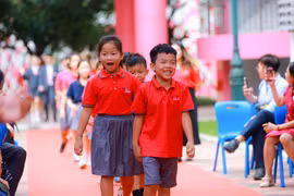 Học sinh mới bước vào trong tiếng vỗ tay chào đón nồng nhiệt. (Ảnh: Minh Sơn/Vietnam+)