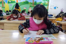 Học sinh lớp 2, Trường Tiểu học Phạm Tu, Thanh Trì, Hà Nội, đi học trở lại sáng ngày 10/2. (Ảnh: Phạm Mai/Vietnam+)