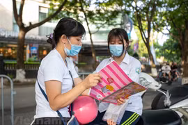 Thí sinh cố gắng tranh thủ xem lại tài liệu trước khi vào khu vực thi. (Ảnh: PV/Vietnam+)