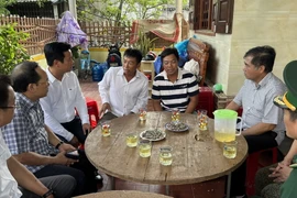 Lãnh đạo tỉnh Quảng Bình thăm hỏi các ngư dân được cứu sống trở về địa phương. (Ảnh: TTXVN phát)