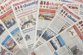 Trang nhất báo Pasaxon và báo Pathet Lao trong những ngày vừa qua đưa tin đậm nét về Chiến thắng Điện Biên Phủ. (Ảnh: Đỗ Bá Thành/TTXVN)