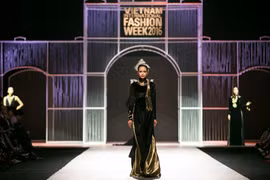 Trên nền nhạc “Hello Vietnam,” Quán quân Vietnam’s Next Top Model mùa thứ 7 Ngọc Châu mở màn show diễn với chiếc áo dài đen cách điệu bằng chất liệu nhung. (Ảnh: BTC)