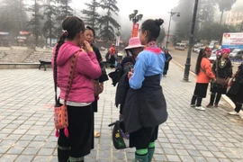 Du khách và người dân tại Sa Pa phải mặc áo chống rét ra đường. (Ảnh: TTXVN)