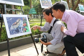 Các đại biểu và người dân thưởng lãm các tác phẩm ảnh nghệ thuật. (Ảnh: Hoài Nam/TTXVN) 