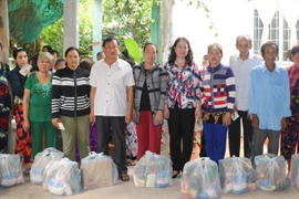 Bí thư Tỉnh ủy An Giang Võ Thị Ánh Xuân và Chủ tịch Ủy ban MTTQ Việt Nam tỉnh An Giang Nguyễn Tiếc Hùng tặng quà cho các hộ bị mất nhà do phải di dời khẩn cấp ra khỏi vùng sạt lở. (Ảnh: Công Mạo/TTXVN)