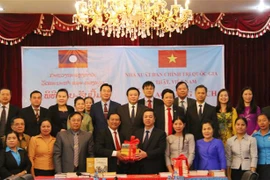 Phó giáo sư, tiến sỹ Vũ Trọng Lâm, Phó Giám đốc, Phó Tổng Biên tập Nhà xuất bản Chính trị quốc gia Sự thật (phải) trao tặng sách lý luận chính trị dịch sang tiếng Lào cho Bộ Thông tin, Văn hóa và du lịch Lào. (Ảnh: Xuân Tú/TTXVN)