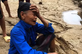 Người dân ra bờ suối mong người thân trở về sau trận lũ dữ. (Ảnh: Trịnh Duy Hưng/TTXVN) 