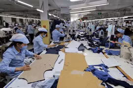 May hàng xuất khẩu tại Công ty trách nhiệm hữu hạn may Đức Giang, Long Biên, Hà Nội. (Ảnh: Trần Việt/TTXVN)