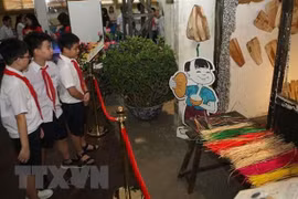 Học sinh tham quan không gian trưng bày 'Tết Đoan Ngọ xưa và nay tại Hoàng thành Thăng Long. (Ảnh: Thanh Tùng/TTXVN)