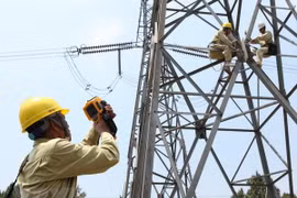 Công nhân Công ty truyền tải điện 2 bảo dưỡng đường dây 500kV Bắc-Nam đoạn qua Thừa Thiên-Huế. (Ảnh: Ngọc Hà/TTXVN)