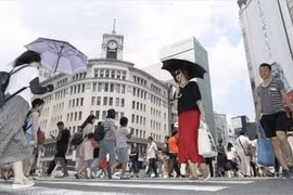 Người dân che ô tránh nắng tại Ginza, thủ đô Tokyo, Nhật Bản ngày 14/7. (Ảnh: Kyodo/TTXVN)