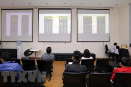 Khách hàng theo dõi bảng giao dịch chứng khoán tại sàn giao dịch BVSC. (Ảnh: Trần Việt/TTXVN) 