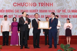 Ông Vương Đình Huệ, Phó Thủ tướng Chính phủ, và ông Trần Thanh Mẫn, Bí thư Trung ương Đảng, Chủ tịch Ủy ban Trung ương Mặt trận Tổ quốc Việt Nam trao Bằng khen của Thủ tướng Chính phủ cho các tập thể có thành tích xuất sắc. (Ảnh: Doãn Tấn/TTXVN)