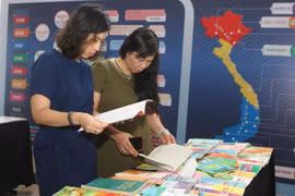 Đại biểu dự hội thảo xem những ấn phẩm in lậu. (Ảnh: Thanh Tùng/TTXVN)