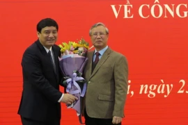 Ông Trần Quốc Vượng, Ủy viên Bộ Chính trị, Thường trực Ban bí thư Trung ương Đảng tặng hoa chúc mừng ông Nguyễn Đắc Vinh. (Ảnh: Văn Điệp/TTXVN)