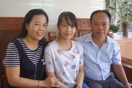 Em Hà Phương và bố mẹ trong niềm vui đón nhận danh hiệu thủ khoa toàn quốc. (Nguồn: TTXVN)