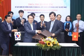 Ông Nguyễn Hồng Minh, Tổng cục trưởng Tổng cục Giáo dục nghề nghiệp và ông Mu Jang Byun, Phó chủ tịch Cơ quan Phát triển nguồn nhân lực Hàn Quốc (HRD) trao bản ký kết thoả thuận hợp tác. (Ảnh: Minh Quyết/TTXVN)