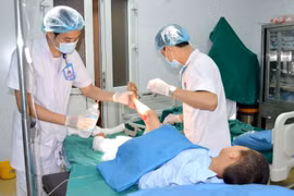 Các y bác sỹ Bệnh viện Đa khoa Hùng Vương điều trị vết thương cho bệnh nhi bị bỏng. (Ảnh: Trung Kiên/TTXVN)
