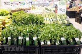 Sử dụng lá chuối tươi gói thực phẩm, nông sản. (Ảnh: Mỹ Phương/TTXVN)