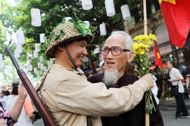 Tái hiện hình ảnh cha con gặp mặt trong ngày Giải phóng thủ đô. (Ảnh: Nhật Anh/TTXVN)