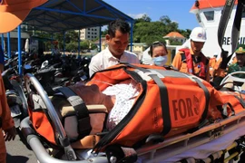 Hành khách gặp nạn Haddock Richard Ray được các nhân viên y tế đưa lên bờ, chuyển vào bệnh viện tại thành phố Nha Trang cấp cứu, điều trị. (Ảnh: Phan Sáu/TTXVN)