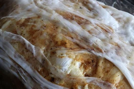 Bánh cuốn sau khi tráng được người dân xã Mão Điền quết lên một lớp hành phi. (Ảnh: Thái Hùng/TTXVN)