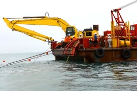 Giai đoạn thả cáp ngầm đang được triển khai từ đảo vào đất liền. (Ảnh: Ngọc Hà/TTXVN)