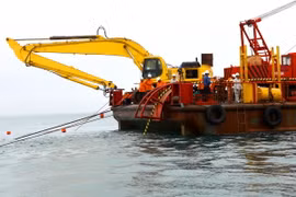 Giai đoạn thả cáp ngầm đang được triển khai từ đảo vào đất liền. (Ảnh: Ngọc Hà/TTXVN)