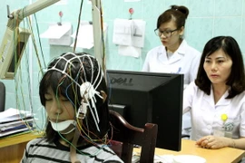 Nhân viên y tế đo điện não kiểm tra sóng bất thường trong não. (Ảnh: Dương Ngọc/TTXVN) 