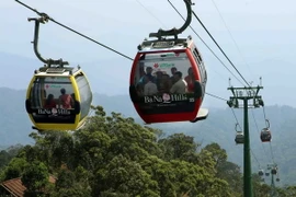 Du khách tham quan ngắm cảnh từ ca bin cáp treo trên đường lên khu du lịch Bà Nà Hills. (Ảnh: Trần Lê Lâm/TTXVN) 