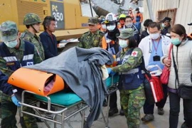 Chuyển thi thể nạn nhân khỏi hiện trường vụ động đất. (Nguồn: Kyodo/TTXVN) 