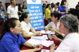 Tư vấn bảo hiểm y tế, bảo hiểm xã hội. (Ảnh: Thanh Vũ/TTXVN) 