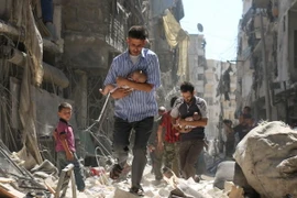 Chuyển các em nhỏ Syria ra khỏi một tòa nhà bị sập sau vụ không kích nhằm vào khu vực Salihin ở thành phố Aleppo, miền bắc Syria ngày 11/9. (Nguồn: AFP/TTXVN) 