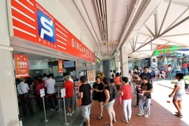 Người dân Singapore xếp hàng đợi cá cược tại một đại lý của Singapore Pools. (Nguồn: straitstimes.com)