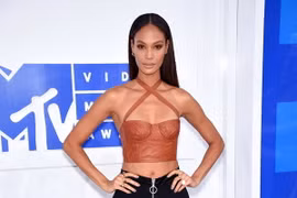 Chân dài Joan Smalls khoe eo thon dáng chuẩn cùng crop top da và quần ống loe, được phối màu theo công thức đối lập
