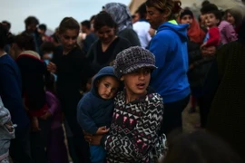 Người tị nạn và di cư xếp hàng đợi nhận khẩu phần ăn tại trại tị nạn. (Nguồn: AFP/TTXVN)