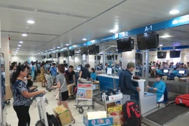 Hành khách đến làm thủ tục check in tại sân bay Tân Sơn Nhất. (Ảnh: Hoàng Hải/TTXVN) 
