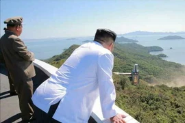 Nhà lãnh đạo Triều Tiên Kim Jong-un (phải) thị sát việc thử nghiệm trên mặt đất động cơ tên lửa công suất lớn tại Trung tâm vũ trụ Sohae, Triều Tiên. (Nguồn: Yonhap/TTXVN) 