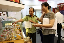 Kiểm tra vệ sinh an toàn thực phẩm một cửa hàng bán bánh trung thu. (Nguồn: TTXVN)