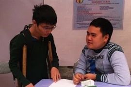 Người khuyết tật đang phỏng vấn xin việc tại ngày hội. (Ảnh: Hồng Kiều/Vietnam+)