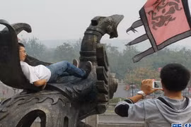 Khách du lịch trèo lên các biểu tượng lịch sử để chụp ảnh lưu niệm. (Nguồn: news.cn)