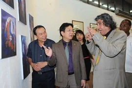 Họa sỹ Ahmed Mohammed El-Ganainy giới thiệu các tác phẩm cho khách tham quan triển lãm. (Ảnh: Minh Đức/TTXVN)