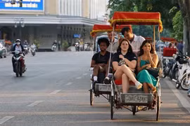 Du khách trải nghiệm du lịch quanh hồ Hoàn Kiếm bằng xíchlô. (Ảnh: Khánh Hòa/TTXVN)