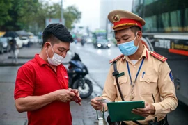 Một trường hợp xe khách đón trả khách sai quy định bị lực lượng CSGT dừng xe, kiểm tra và lập biên bản. (Ảnh: Phạm Kiên/TTXVN)