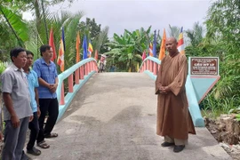 Thượng tọa Thích Định Hương trao đổi với người dân tham gia thực hiện công trình tại huyện Thạnh Trị, tỉnh Sóc Trăng tron. (Ảnh: Tuấn Phi/TTXVN)