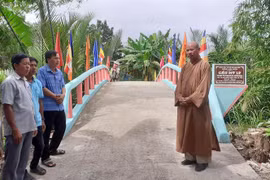 Thượng tọa Thích Định Hương trao đổi với người dân tham gia thực hiện công trình tại huyện Thạnh Trị, tỉnh Sóc Trăng tron. (Ảnh: Tuấn Phi/TTXVN)