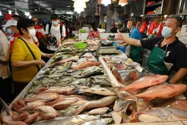 Người tiêu dùng mua sắm tại khu chợ ở Singapore. (Ảnh: AFP/TTXVN)