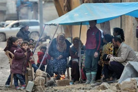 Người dân đốt lửa sưởi ấm trong thời tiết giá lạnh do bị mất nhà cửa sau trận động đất tại Jindayris, Syria, ngày 7/2/2023. (Ảnh: AFP/TTXVN)