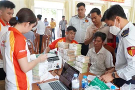 Người dân ở xã Mỹ Thọ, huyện Cao Lãnh (Đồng Tháp) nhận tiền bồi thường, hỗ trợ. (Ảnh: Nhựt An/TTXVN)